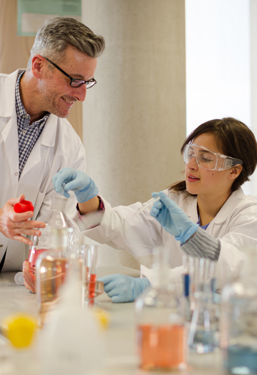 Männlicher Lehrer und Schüler führen wissenschaftliche Experimente im Laborraum durch