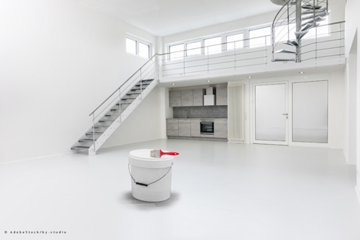 weißer Raum mit Farbkübel und Pinsel