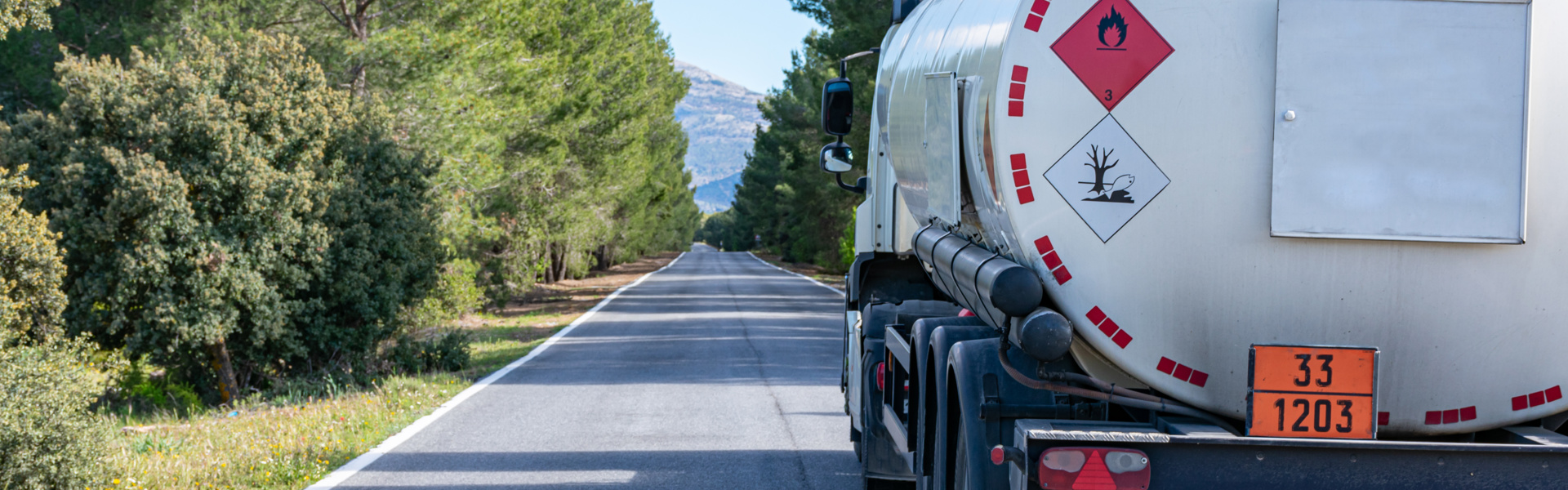 LKW auf Landstraße mit Gefahrgutsymbol