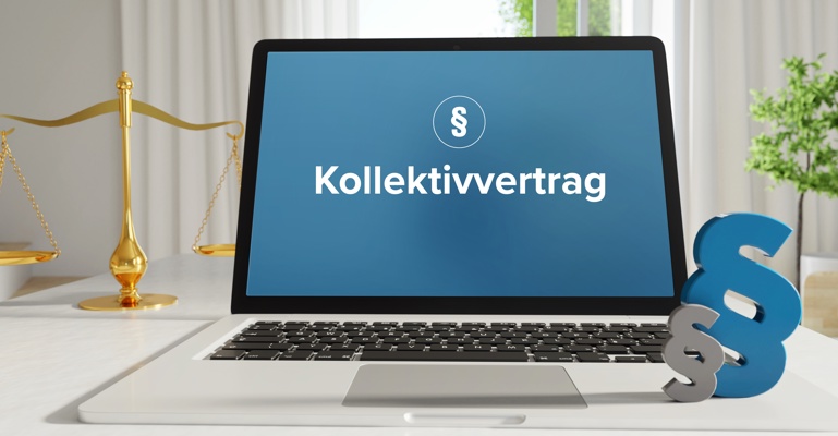 Laptop im Büro mit Begriff Kollektivvertrag auf dem Monitor - daneben  Paragraf und Waage