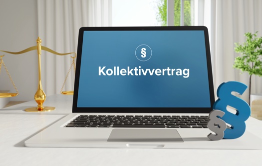 Laptop im Büro mit Begriff Kollektivvertrag auf dem Monitor - daneben  Paragraf und Waage